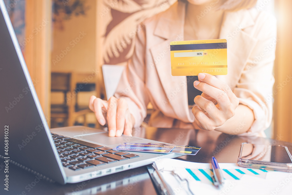 Business people holding credit cards and using laptops shopping online.