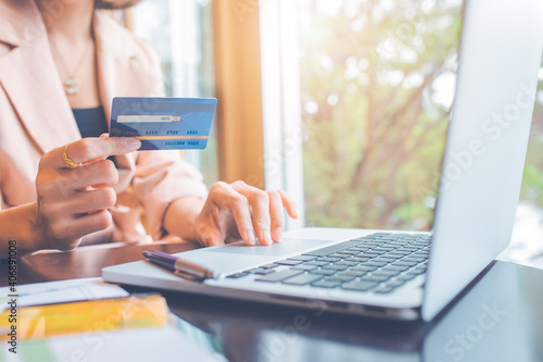 Business people holding credit cards and using laptops shopping online.