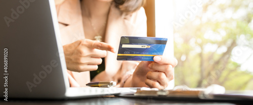 Business people holding credit cards and using laptops shopping online.