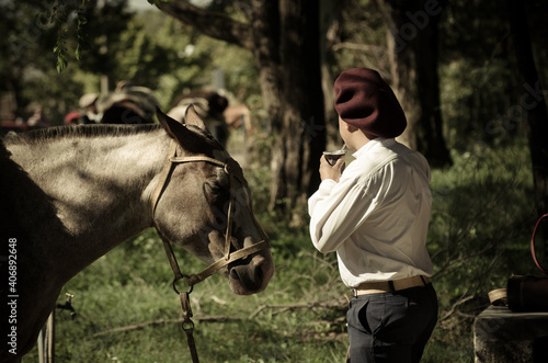 Gaucho tomando mate al lado del caballo © Leonardo