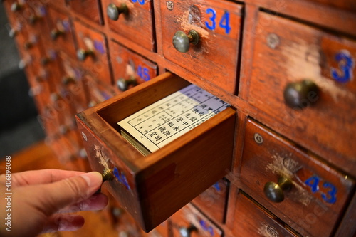 Longshan Temple, Taipei, Taiwan - January 15, 2021: a close-up shot of a hand that opens a wooden cabinet used to store the Esiimsi paper sheets. photo