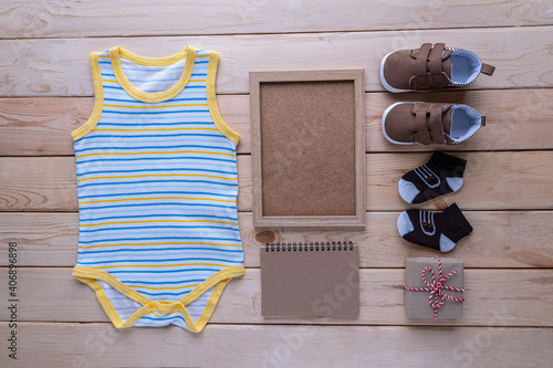 The clothes for kids for babies set with accessories on the wooden table.