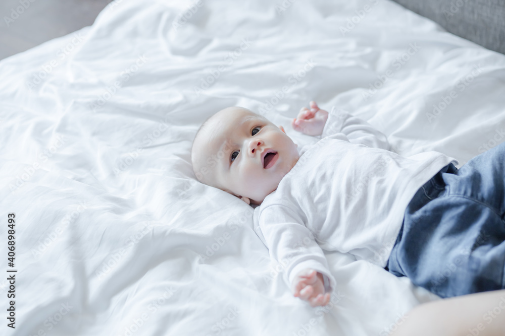 Cute baby on white bed. Baby, newborn concept.