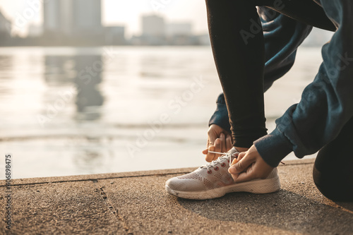 Woman tying shoe laces. Woman fitness runner get ready for jogging on way in the city.