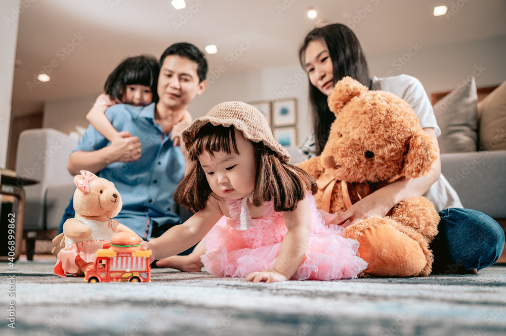 Happy family,Parents play with teddy bears and toys with their children sitting on the rug in the living room at home.Weekend activity happy family lifestyle concept. Happy family,Parents play with teddy bears and toys with their children sitting on the rug in the living room at home.Weekend activity happy family lifestyle concept.