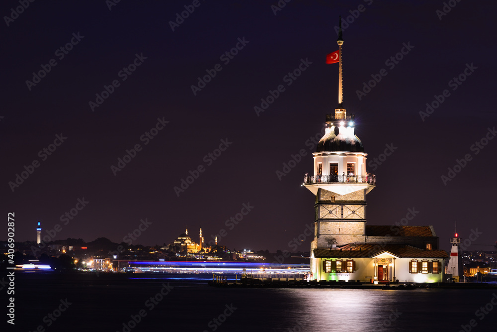 Historical Maiden's Tower or Kiz Kulesi at night with motion blur boats - Istanbul, Turkey.
