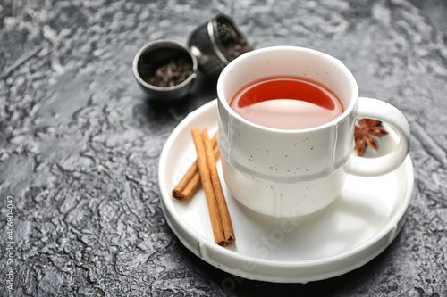 Cup of hot aromatic tea on dark background