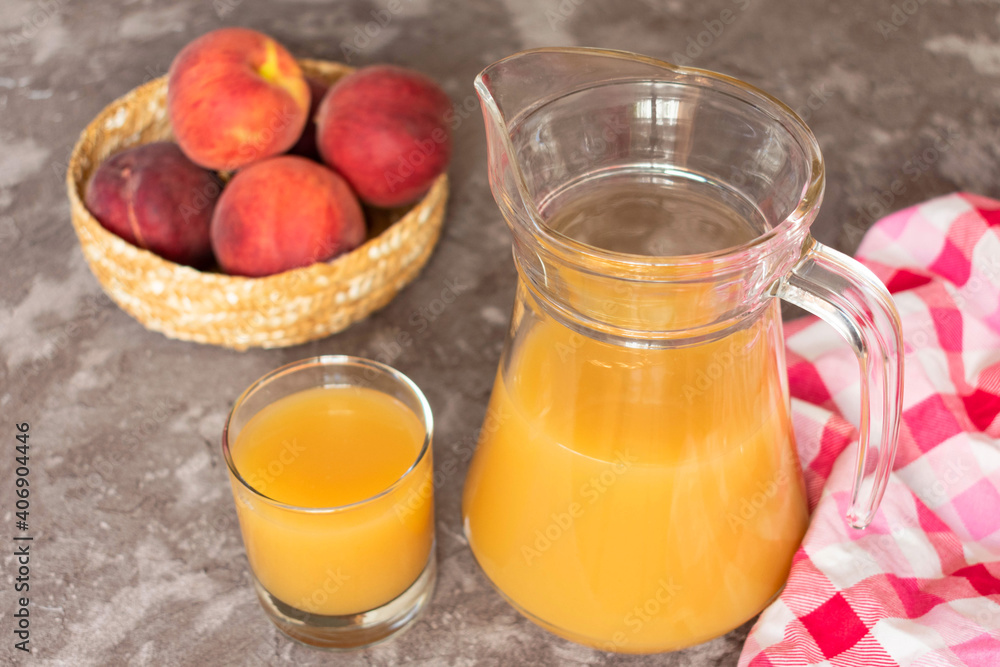 Peach juice in a jug on a gray background.
Close-up.
Peach juice in a jug on a gray background.
Close-up.