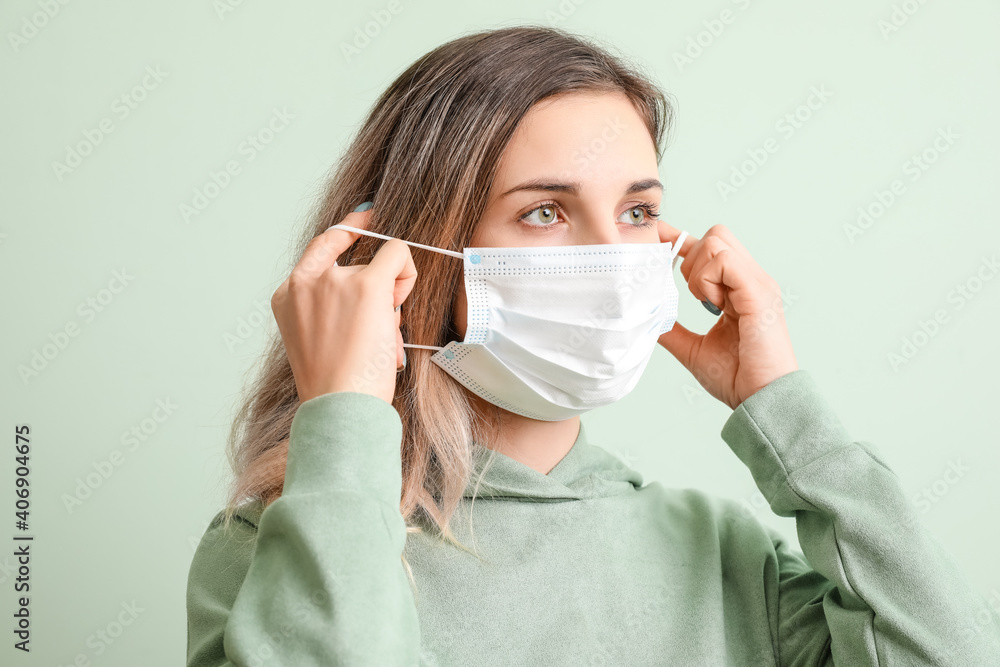 Young woman wearing medical mask on color background Young woman wearing medical mask on color background