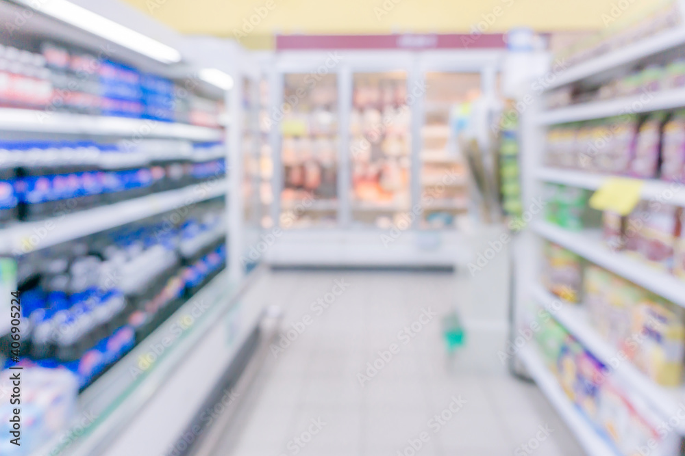Abstract blurred Supermarket aisle with colourful products on display shelves as background.