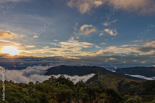 Beautiful landscape in the mountains at sunset. View of foggy hills covered by forest in North Thailand. © Chalearmrat