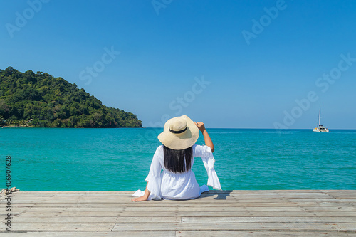 Beautiful Girl in sea style sitting on wooden bridge. Travel Freedom Concept.