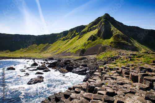 Landscape of Giant's Causeway trail with a blue sky in summer in Northern Ireland, County Antrim. UNESCO heritage. It is an area of basalt columns, the result of an ancient volcanic fissure eruption photo