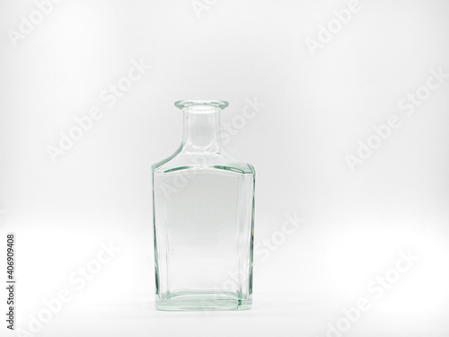 Single empty glass bottle on a white background. Transparent square bottle. Front view of the vertical staying colorless jar.