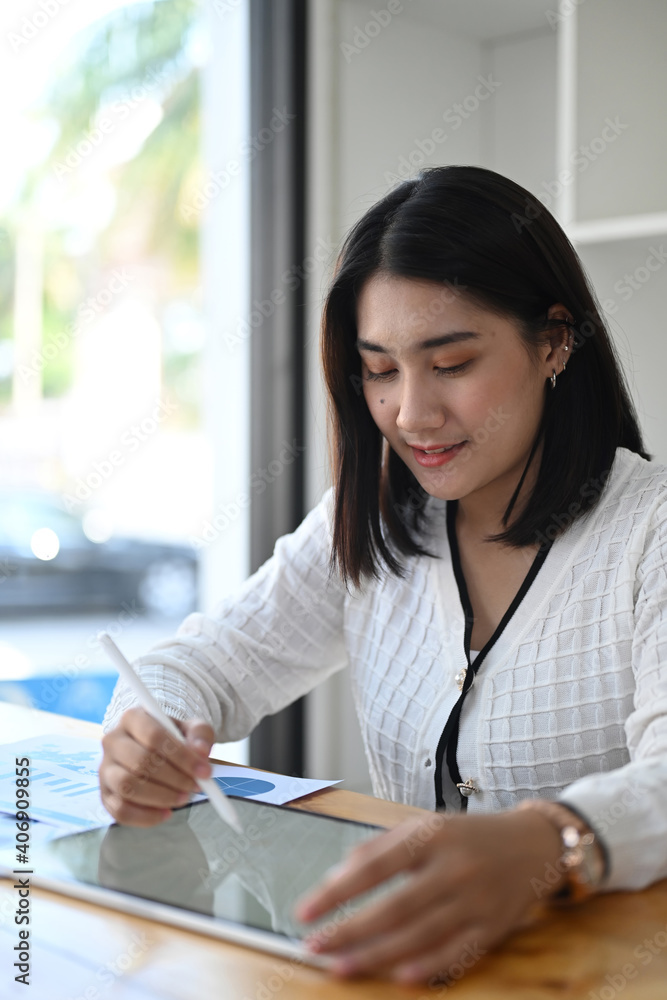 Portrait of of businesswoman holding stylus pen writing on screen of digital tablet at workplace. Portrait of of businesswoman holding stylus pen writing on screen of digital tablet at workplace.