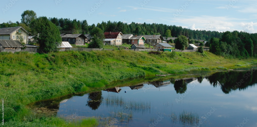 village on the river bank in summer
