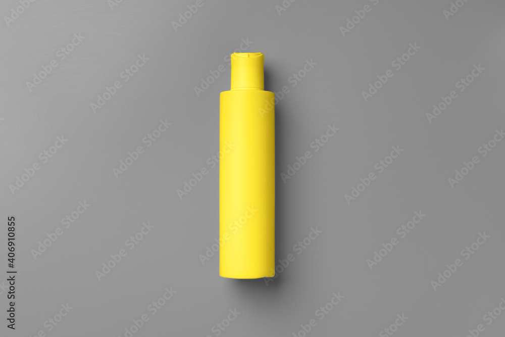 Yellow cosmetic container on gray background top view Yellow cosmetic container on gray background top view
