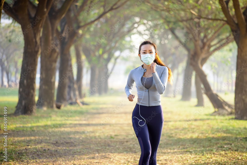 young woman in face mask and running in the park young woman in face mask and running in the park