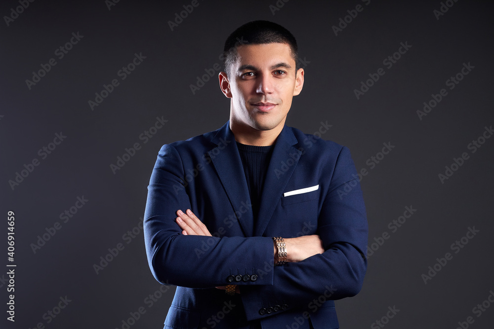 Portrait of a businessman in blue jacket on dark background in studio. man with short haircut. Young confident manager smiles