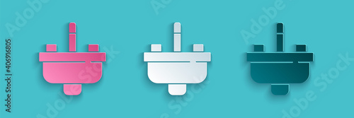 Paper cut Washbasin with water tap icon isolated on blue background. Paper art style. Vector.