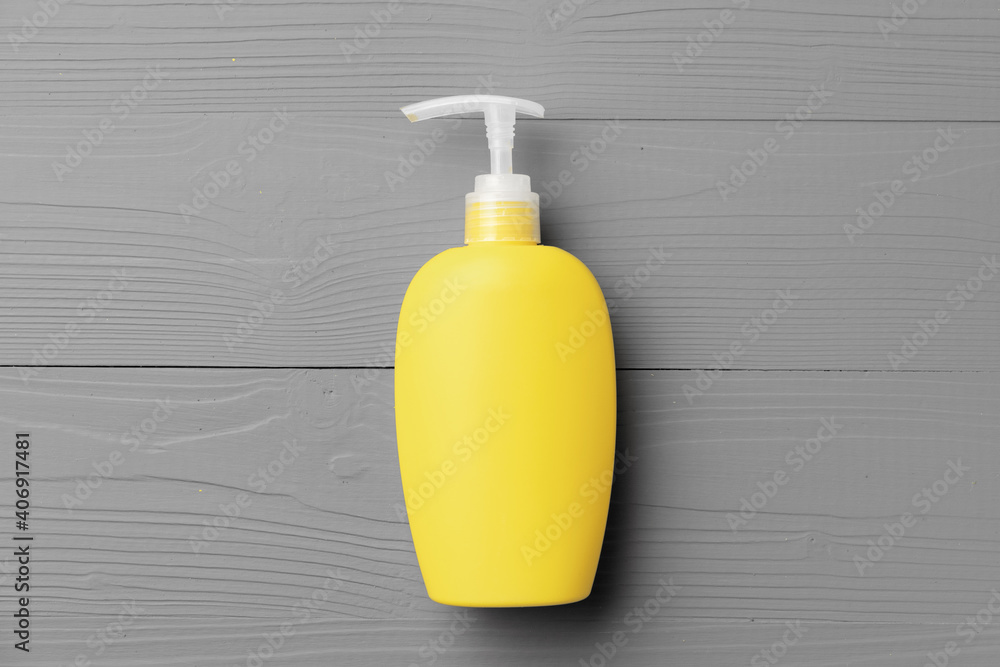 Yellow cosmetic container on gray background top view Yellow cosmetic container on gray background top view