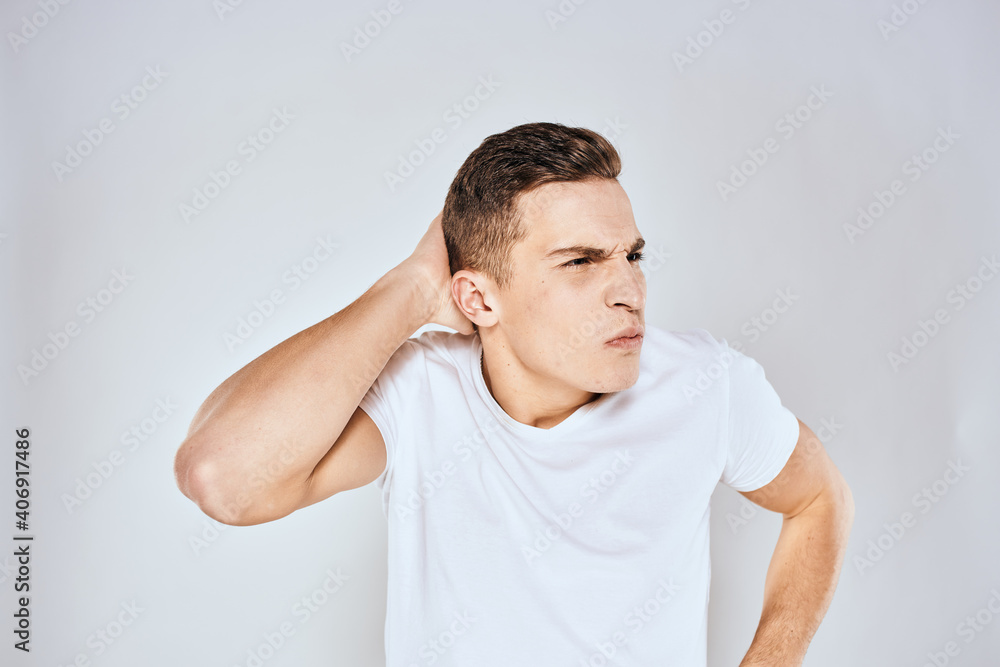 Nice man in a white t-shirt gestures with his hands emotions surprise studio Nice man in a white t-shirt gestures with his hands emotions surprise studio