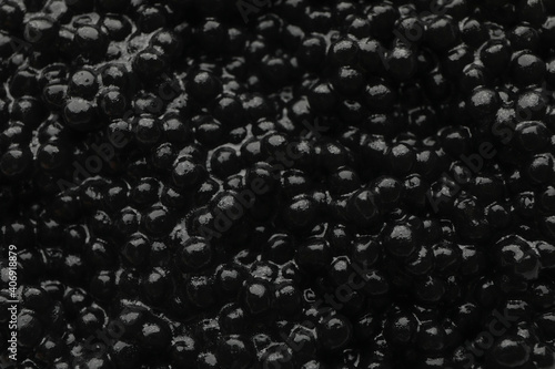 Fresh black caviar on whole background, close up