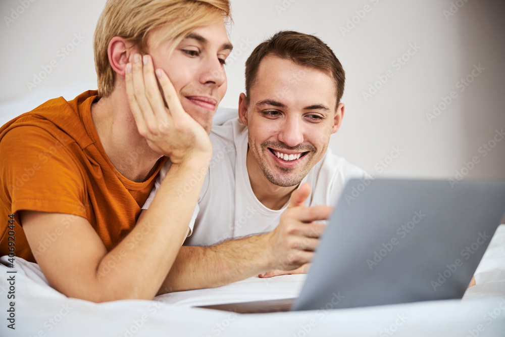 Happy homosexual couple using notebook at home Happy homosexual couple using notebook at home