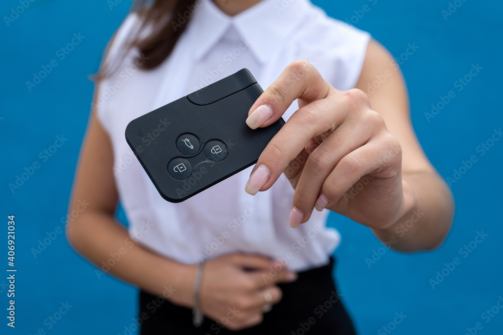 Business woman hold car keys isolated on blue background.