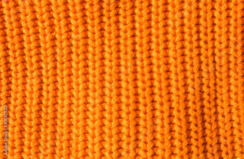 Texture of knitted orange fabric as background, closeup