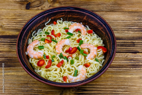 Instant noodle with shrimps, red pepper and green onion in a ceramic bowl. Japanese food