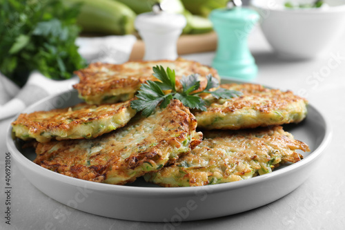 Delicious zucchini fritters served on light table, closeup