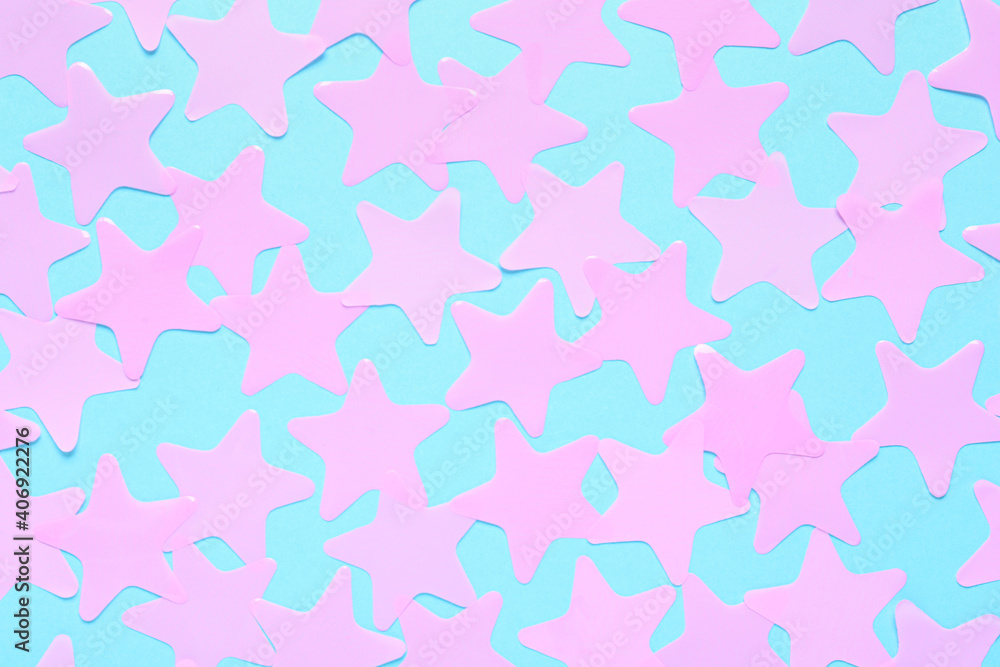 Pink star shaped confetti on light blue background, flat lay