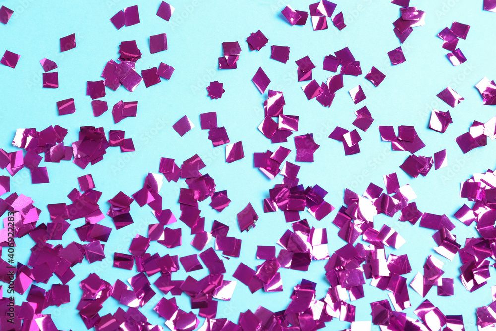 Shiny purple confetti on light blue background, flat lay Shiny purple confetti on light blue background, flat lay