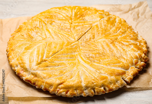 Traditional galette des rois on white wooden table, closeup