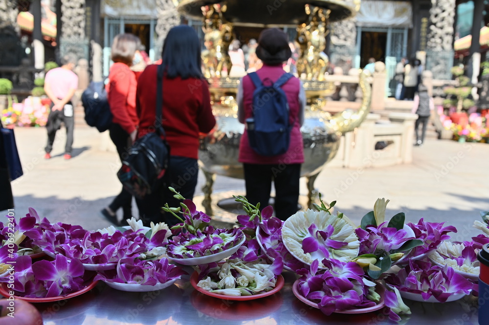 Longshan Temple, Taipei, Taiwan - January 15, 2021: the worshippers place their tribute on the table and hands together to worship the Gods.