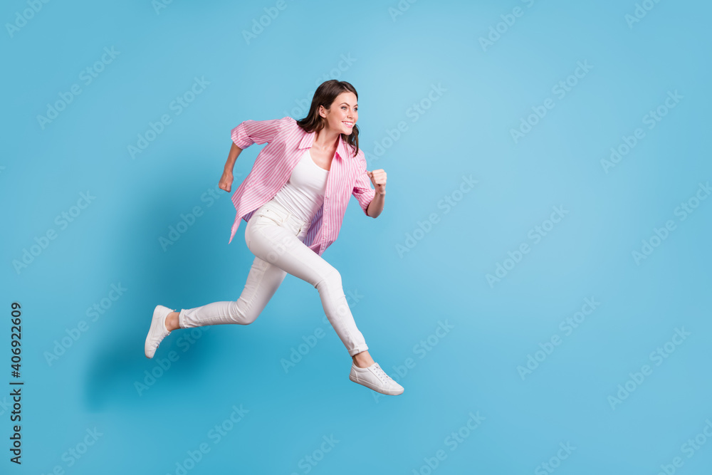 Full size profile photo of charming person running empty space toothy smile white pants isolated on blue color background Full size profile photo of charming person running empty space toothy smile white pants isolated on blue color background