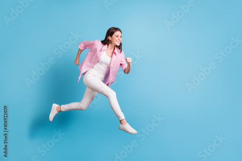 Full size profile photo of charming person running empty space toothy smile white pants isolated on blue color background © deagreez