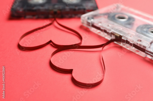 Music cassettes and hearts made with tape on red background, closeup. Listening love songs