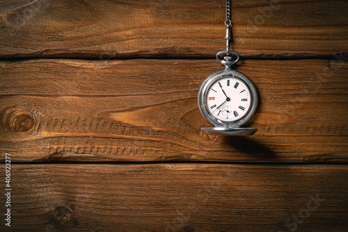 Old vintage pocket watch on the chain on wooden table background. Toned. Mock up. Top view. Blank space for text