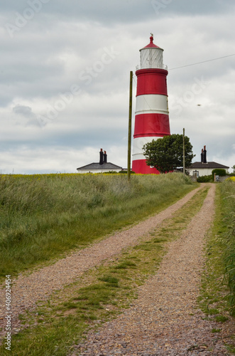 Happisburgh lighthouse against cloudy sky.