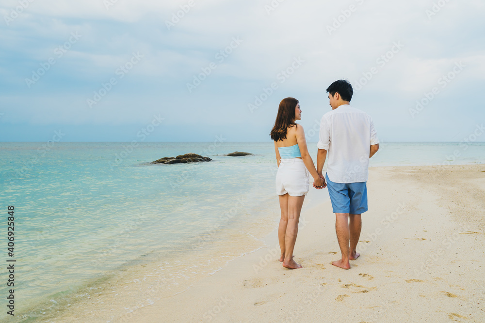 happy young couple walking on sea beach at Koh MunNork Island, Rayong, Thailand