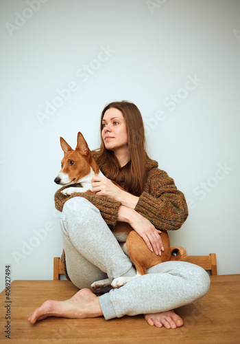 Fototapeta Naklejka Na Ścianę i Meble -  Sitting woman holding basenji dog.