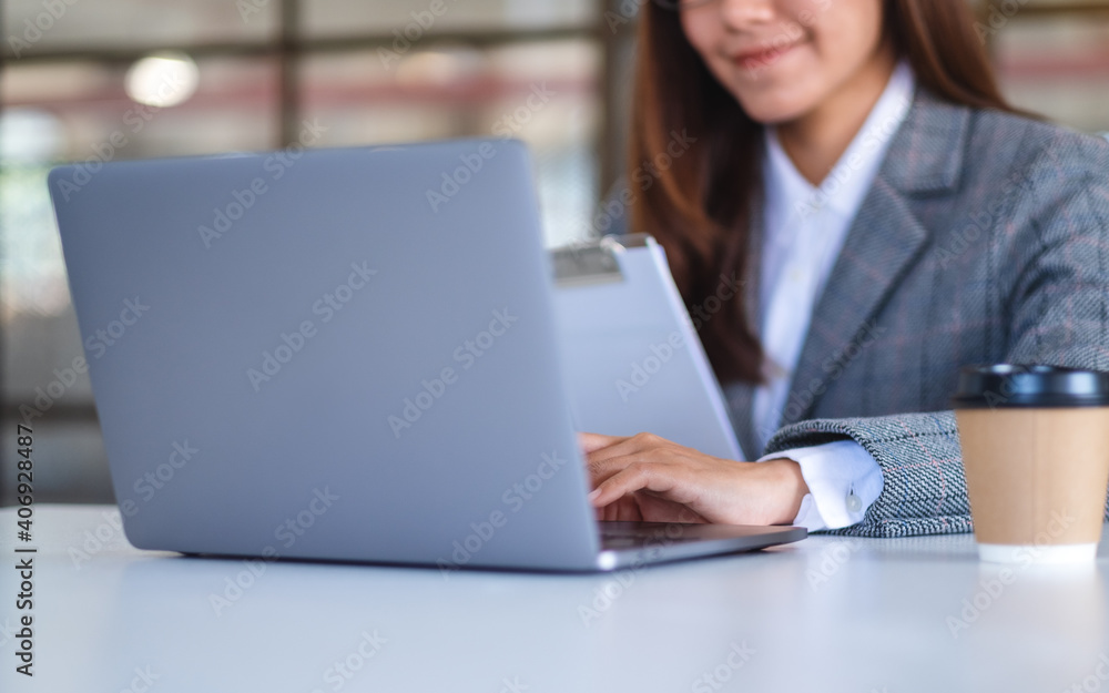 Closeup image of an asian business woman using laptop computer while working in office Closeup image of an asian business woman using laptop computer while working in office
