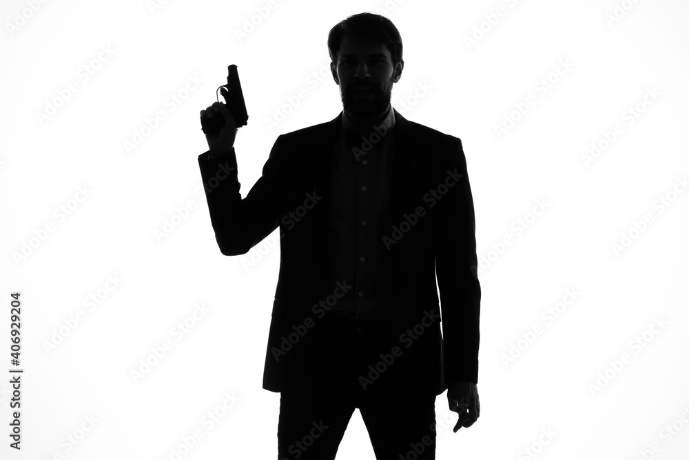 shadow of a man with a gun in his hands aiming detective crime light background