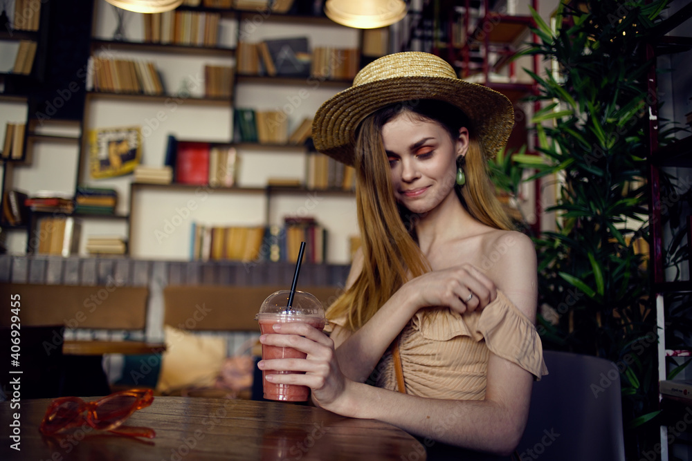 Beautiful woman sits at a table in a cafe glass of juice relaxation more fun