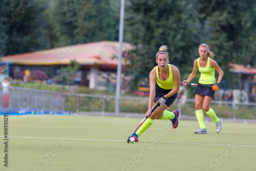 Young field hockey female player in attack