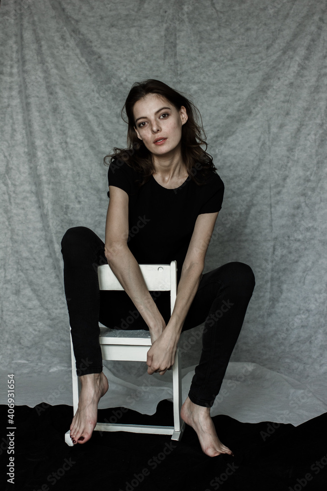 Fototapeta premium woman in black sitting on a chair