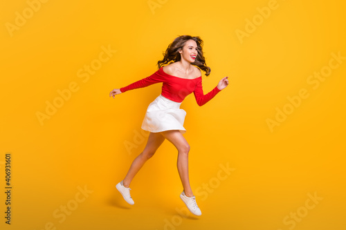 Full length body size photo jumping girl running fast on sale black friday laughing isolated on bright yellow color background copyspace