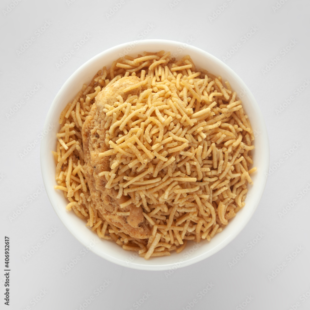 Indian spicy snacks (Namkeen) - Bikaneri Besan Bhujia, made with chickpea flour (Besan), top view against white background. Indian spicy snacks (Namkeen) - Bikaneri Besan Bhujia, made with chickpea flour (Besan), top view against white background.